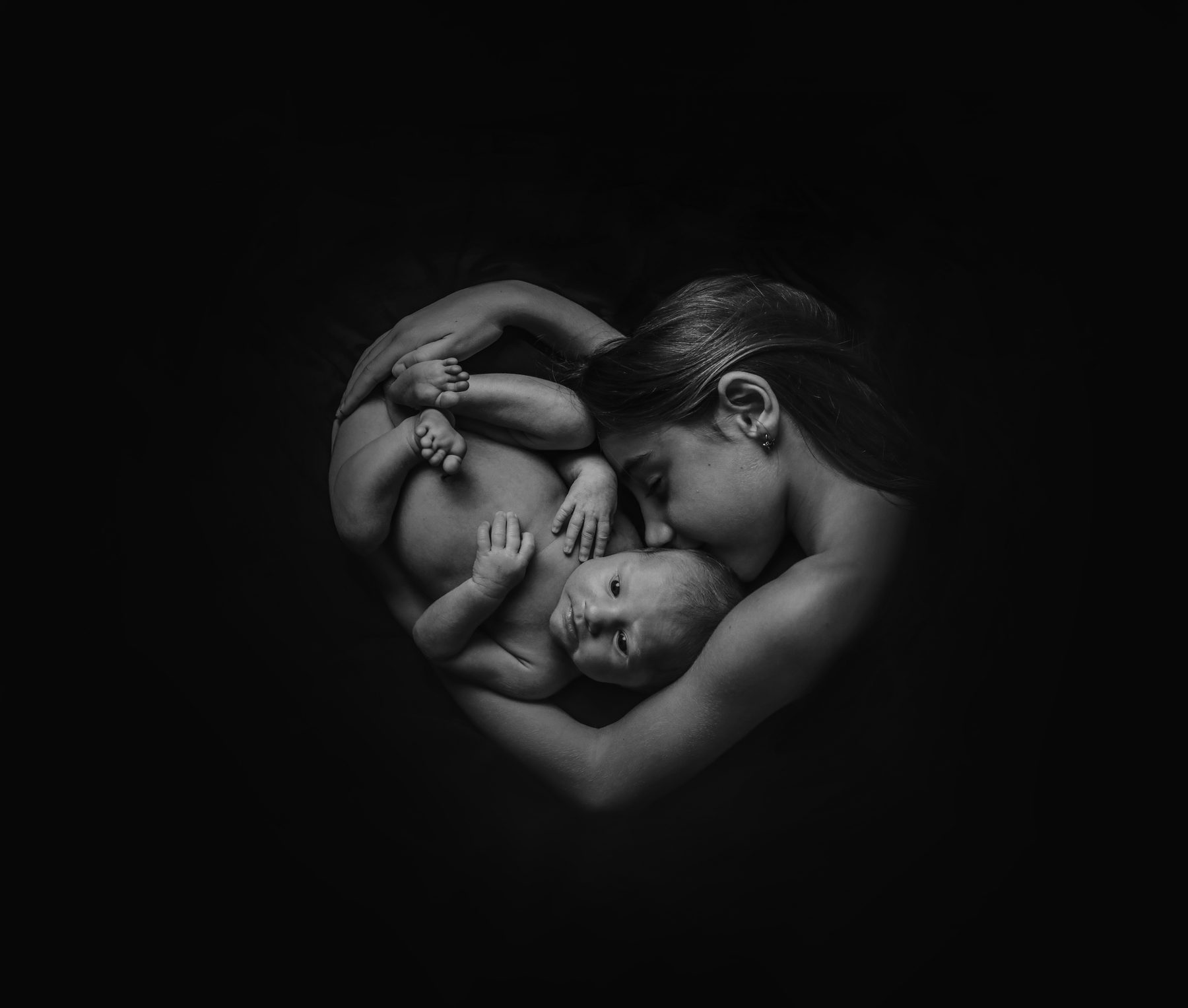Fotografía artística de madre y bebé formando un círculo, en blanco y negro