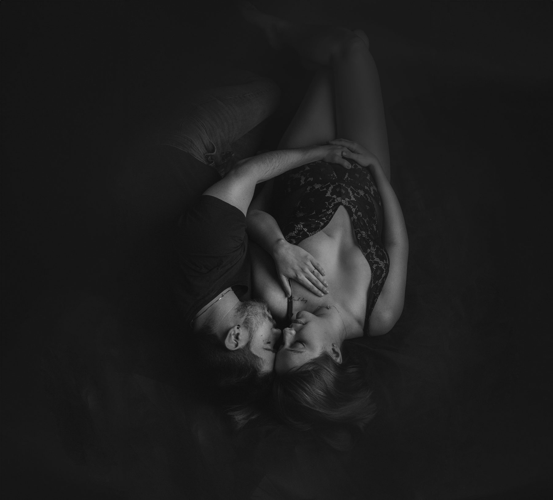 Manos sobre la barriga en una sesión de fotos de embarazo en blanco y negro