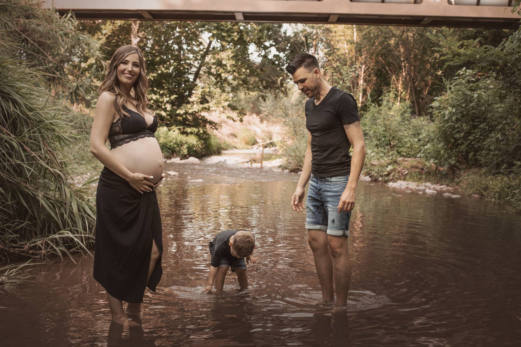 Familia en el río durante una sesión de embarazo en el Montseny