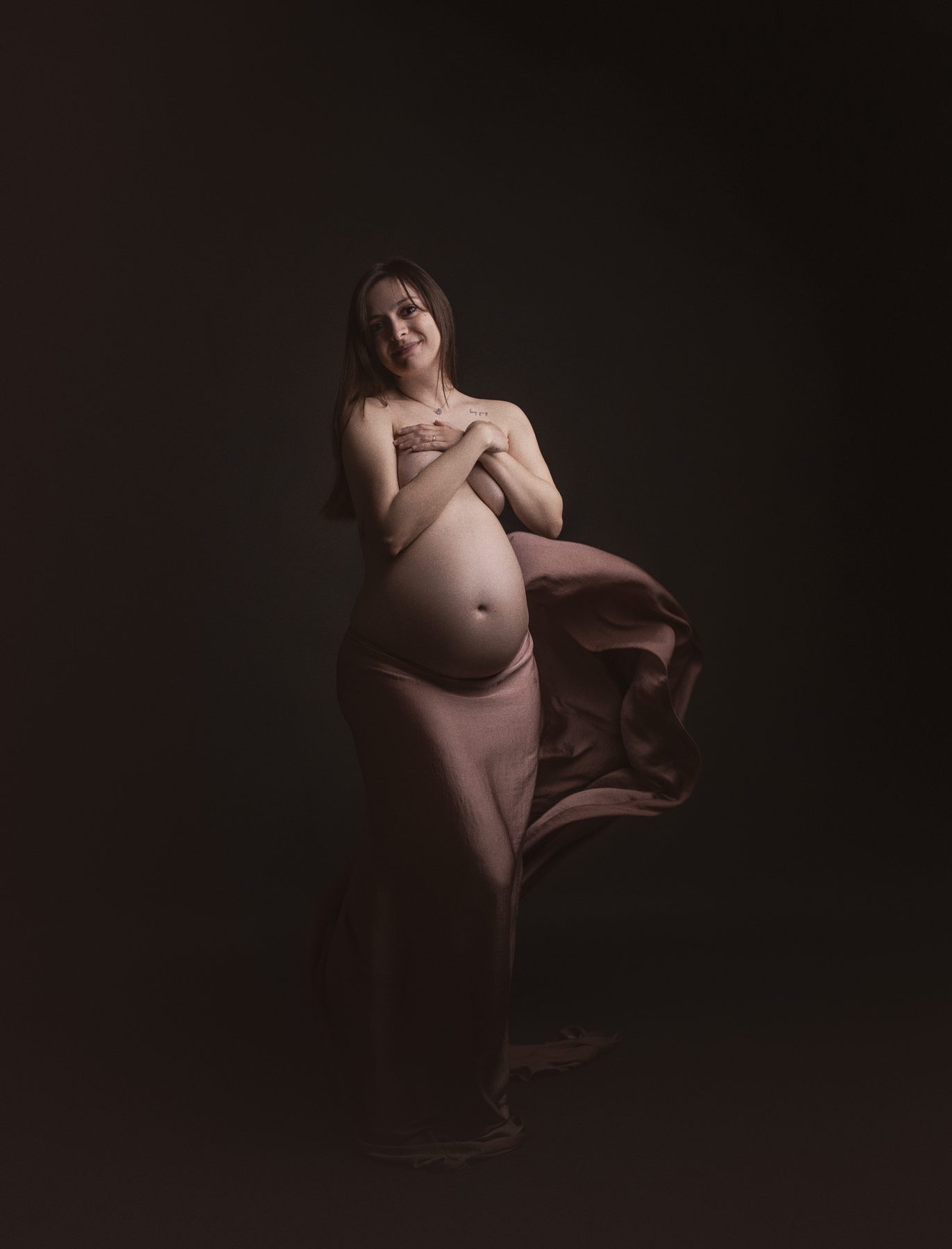 Sesión de fotos de embarazo con tela en tonos tierra en el estudio de Sant Celoni