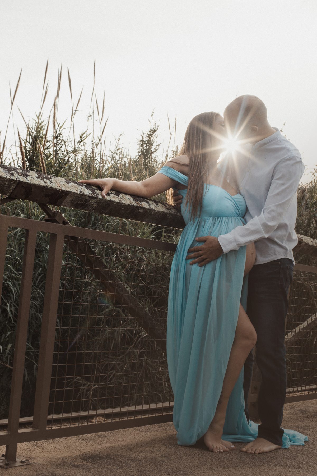 Sesión de fotos de embarazo en pareja en exterior al atardecer