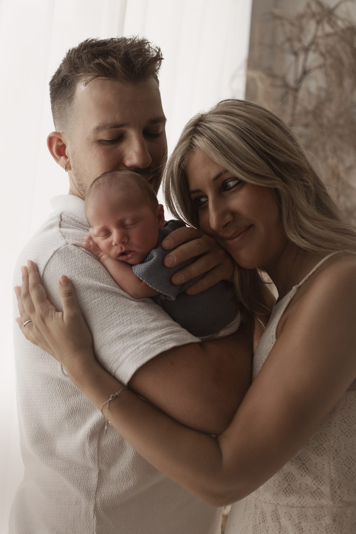 Padre y madre sosteniendo a su bebé recién nacido en el estudio