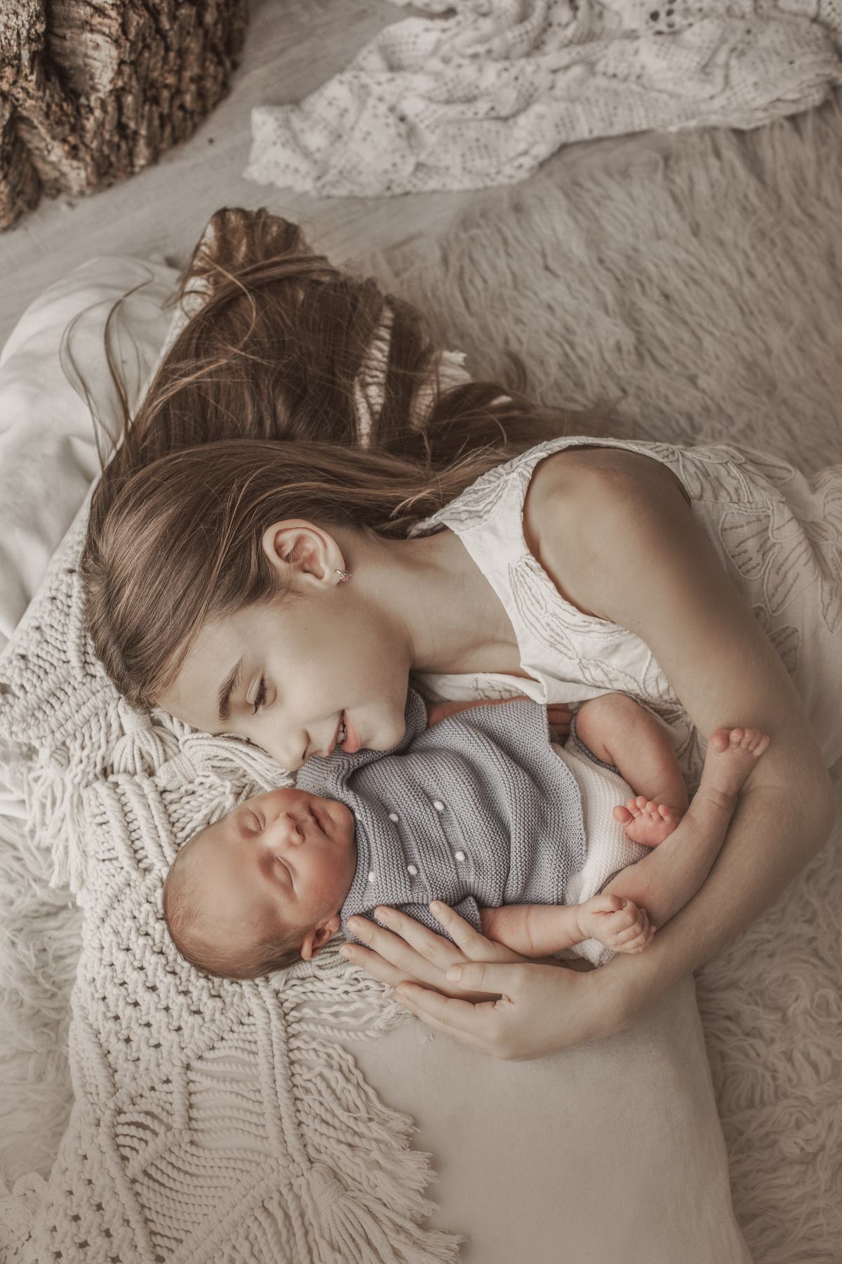 Madre y bebé tumbados en el estudio durante una sesión newborn