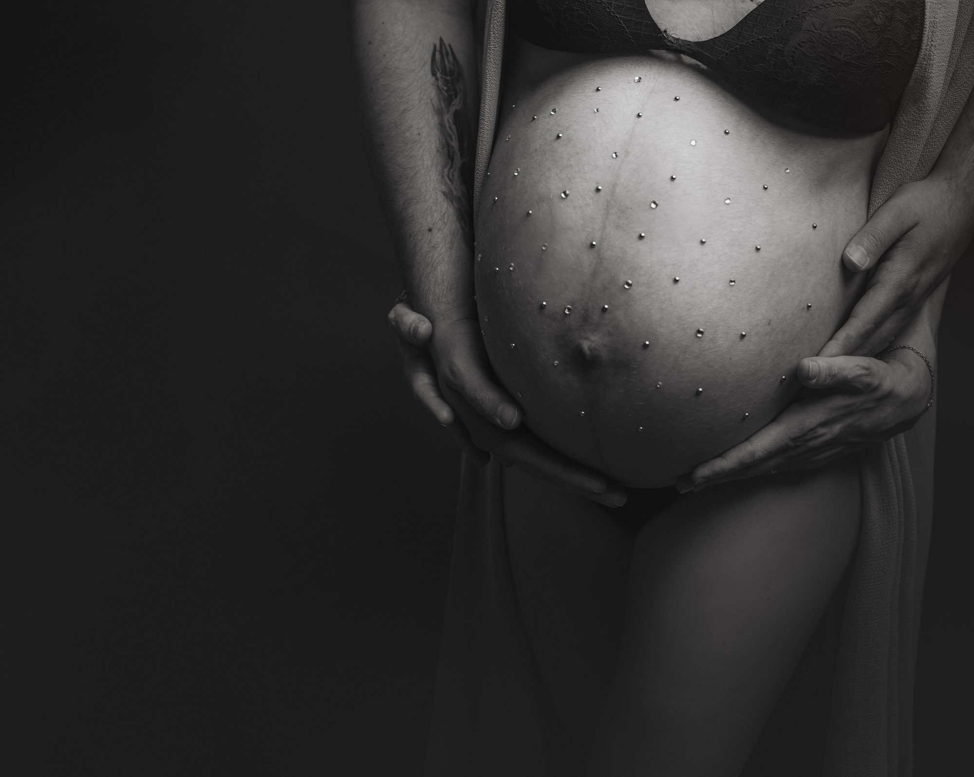 Manos sobre la barriga embarazada en blanco y negro