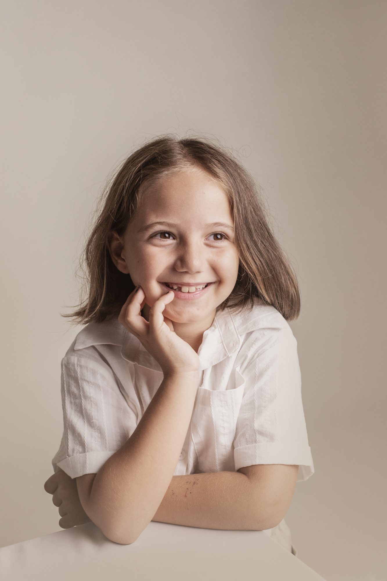 Niña sonriendo, fondo claro