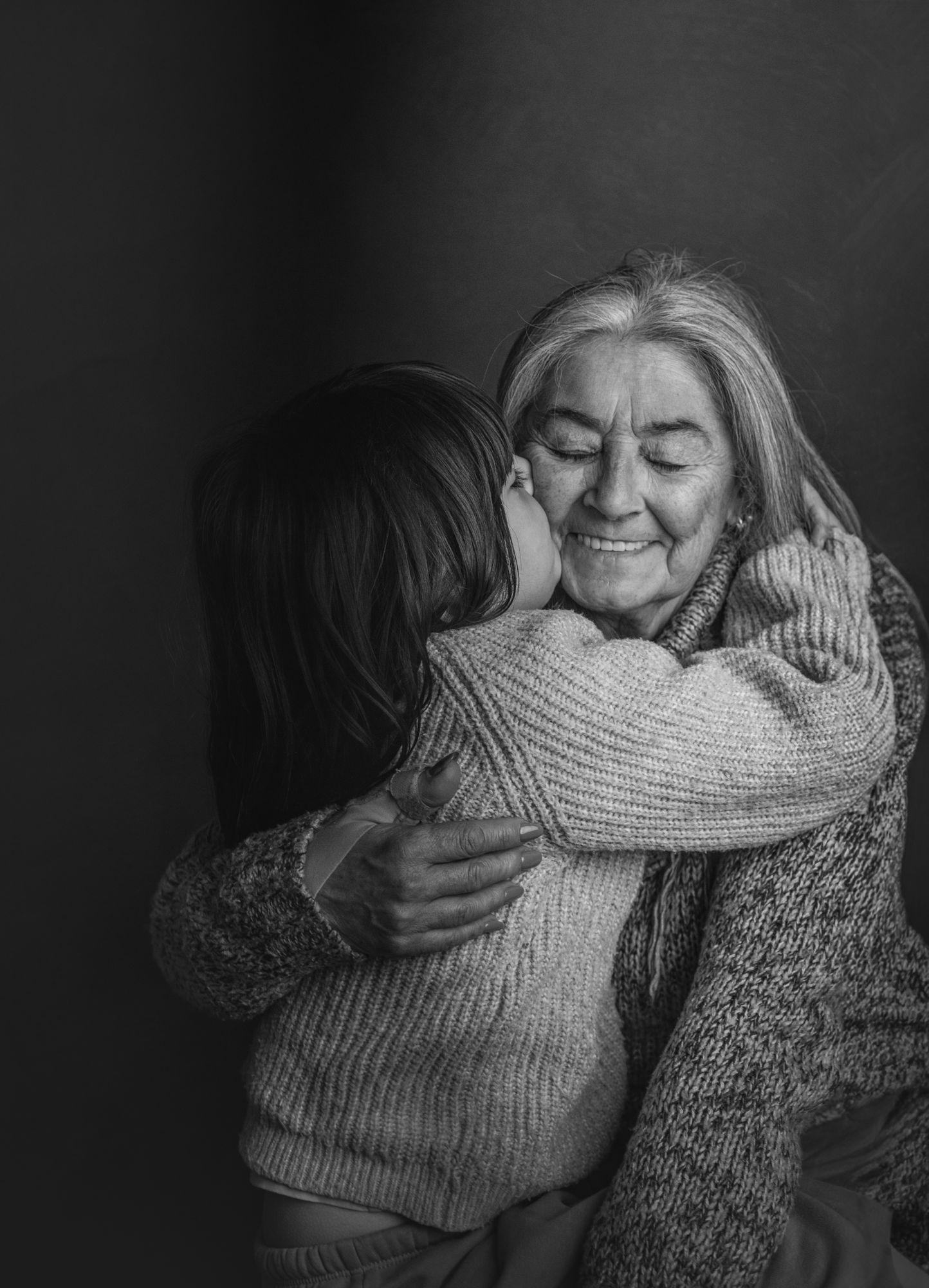 Nieta abrazando a su abuela, en blanco y negro