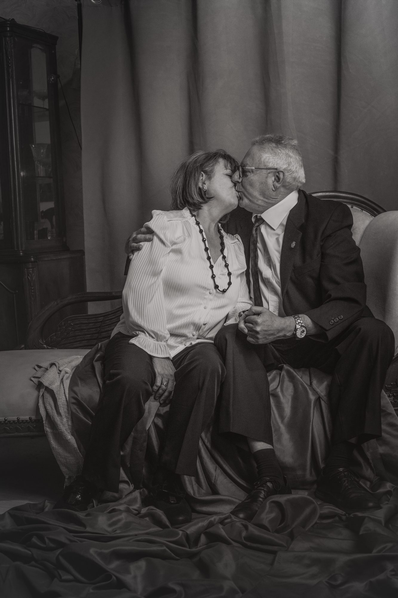 Abuelos besándose en el sofá del estudio
