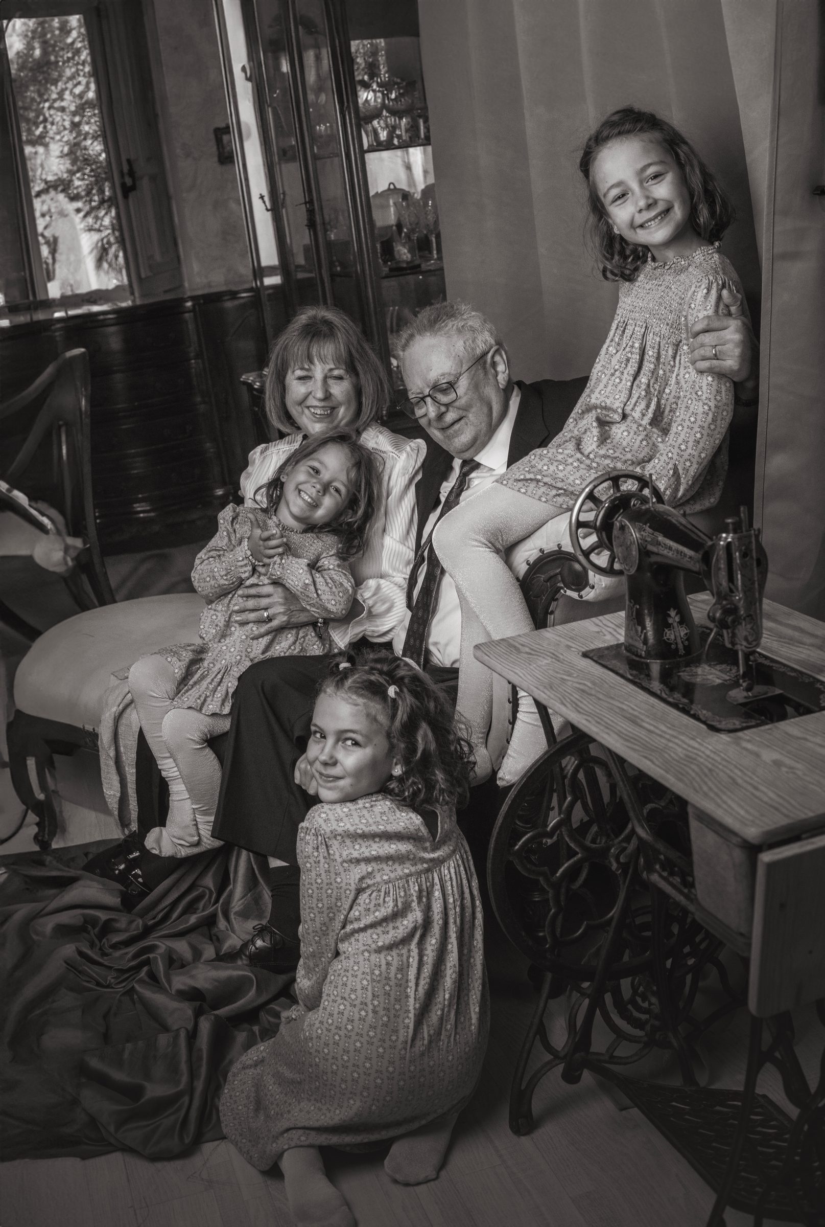 Abuelos con sus nietas junto a una máquina de coser antigua