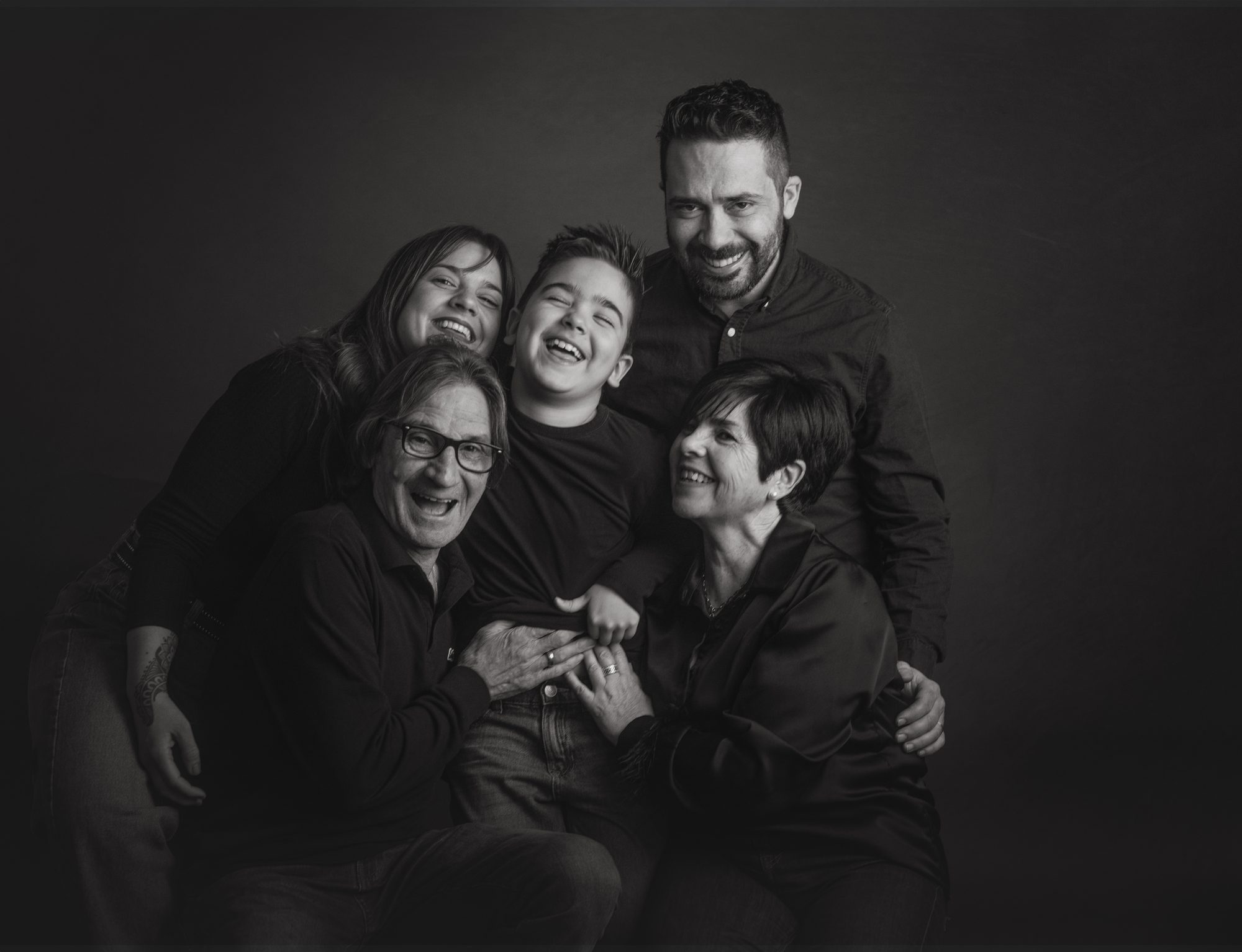 Familia riéndose en el estudio durante una sesión de fotos natural