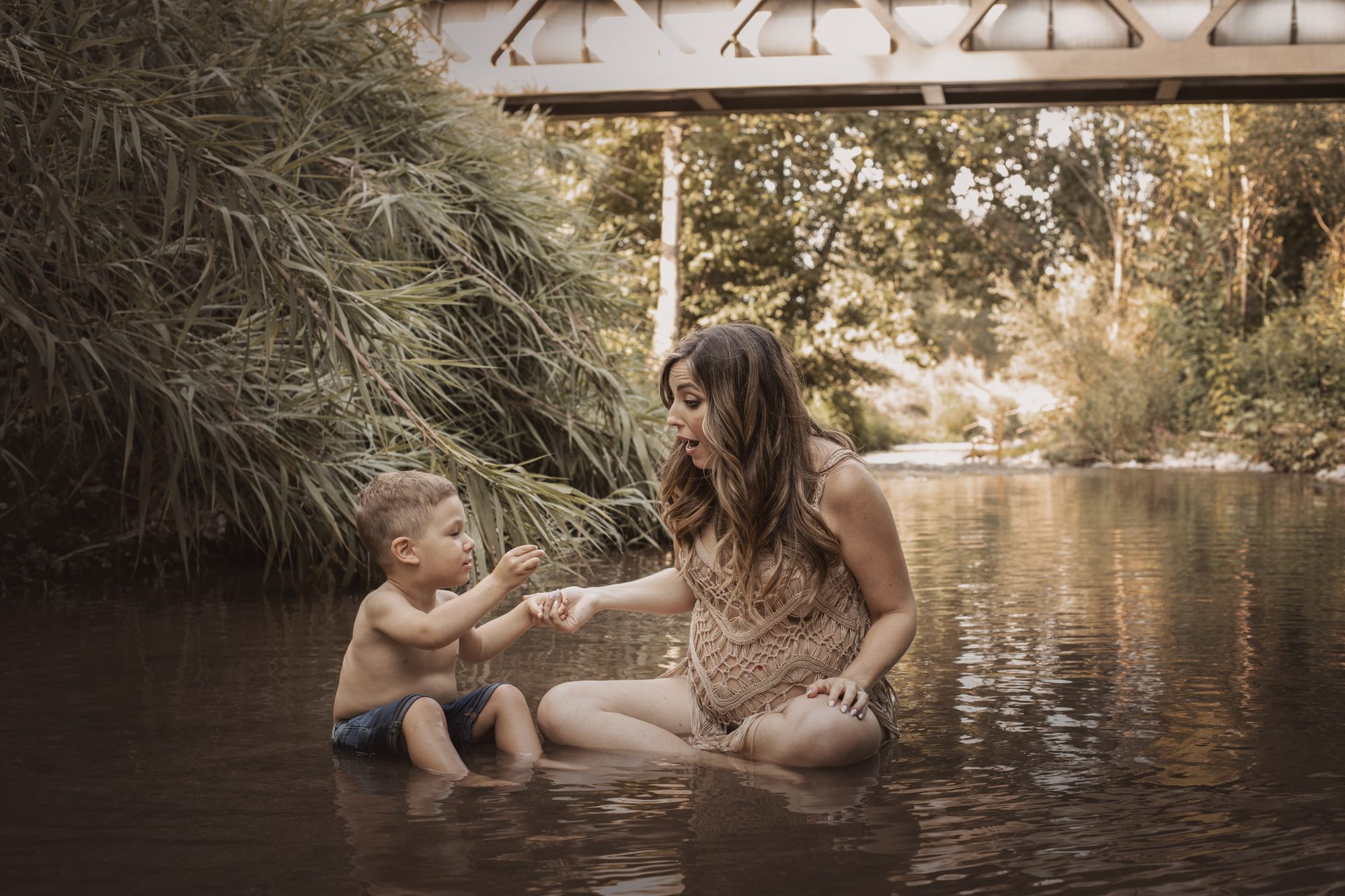 Madre embarazada jugando con su hijo en el río