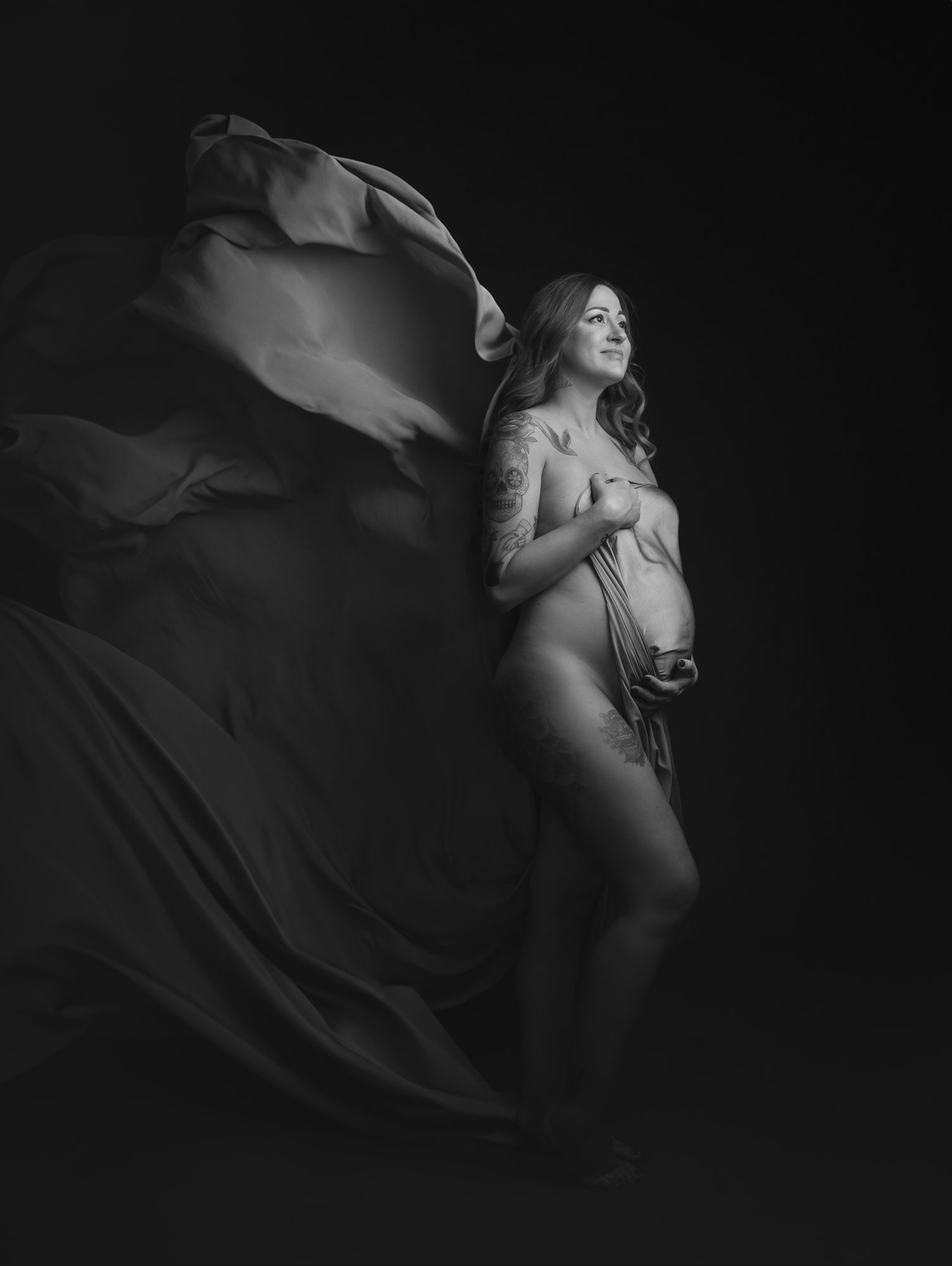 Fotografía artística de embarazo con tela en movimiento