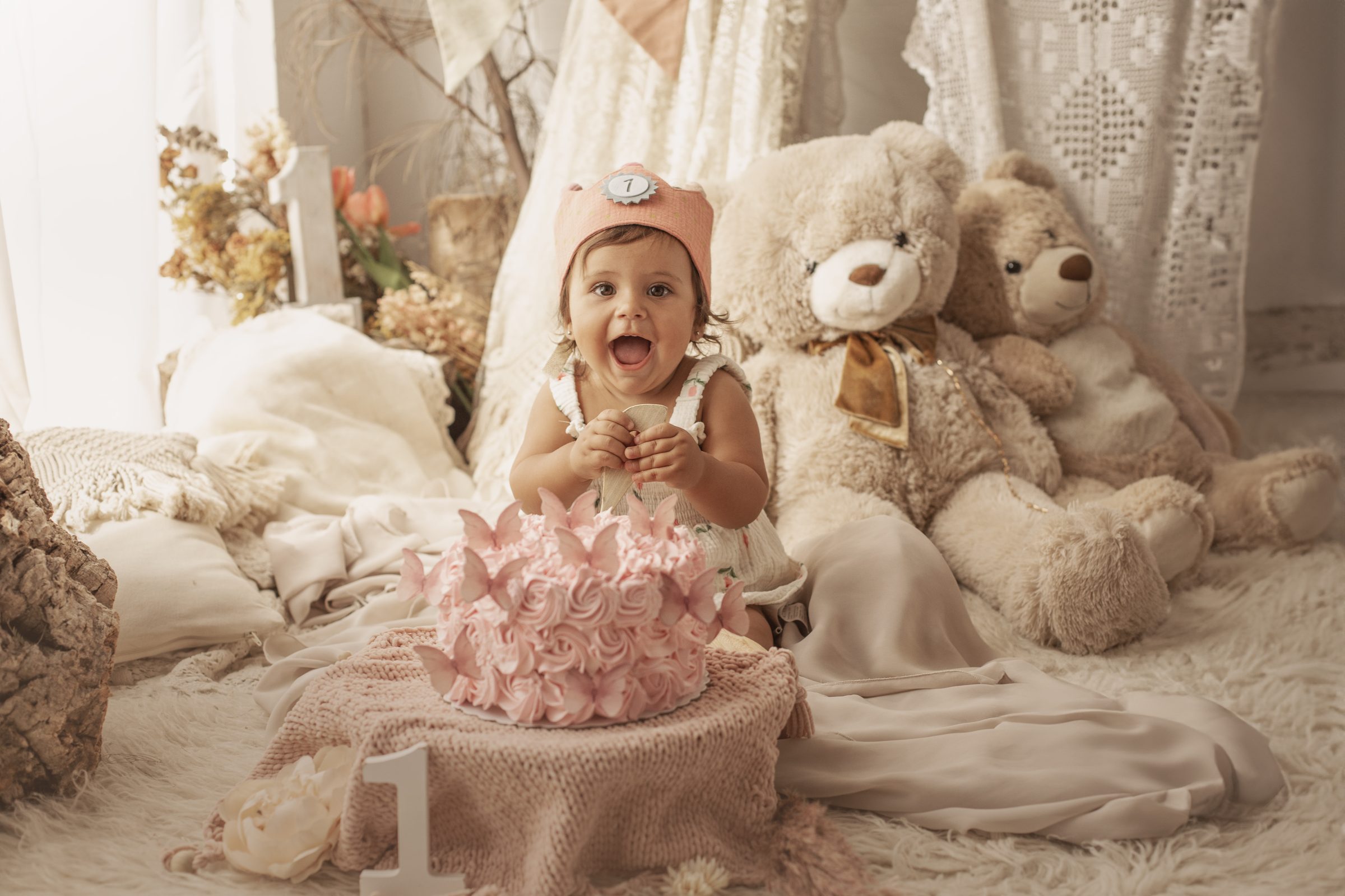 Niña con pastel rosa y ositos en su sesión smash cake
